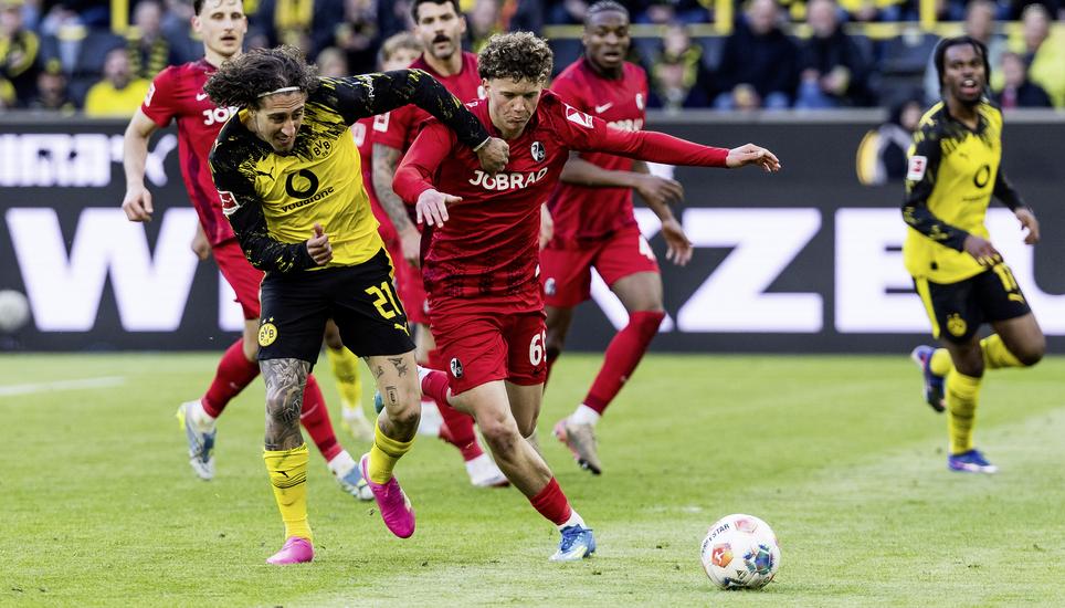 DORTMUND, GERMANY - APRIL 26: Fabio Silva (Borussia Dortmund, 21) and Rouven Vuk Tarnutzer (Freiburg, 69) battle for the ball during the Bundesliga [Bundesliga] match between Borussia Dortmund vs. Freiburg at Signal Iduna Park on matchday 31 of the 1. Bun