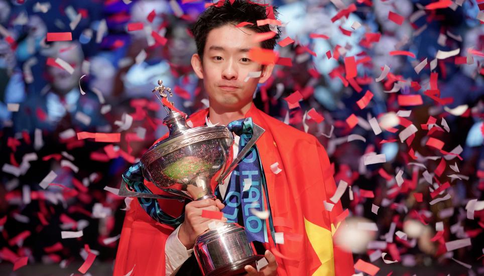 China's Wu Yize poses for the media with the trophy and wearing the Chinese national flag, after winning the World Snooker Championship defeating England's Shaun Murphy in Sheffield, England, Monday, May 4, 2026.(AP Photo/Ian Hodgson)