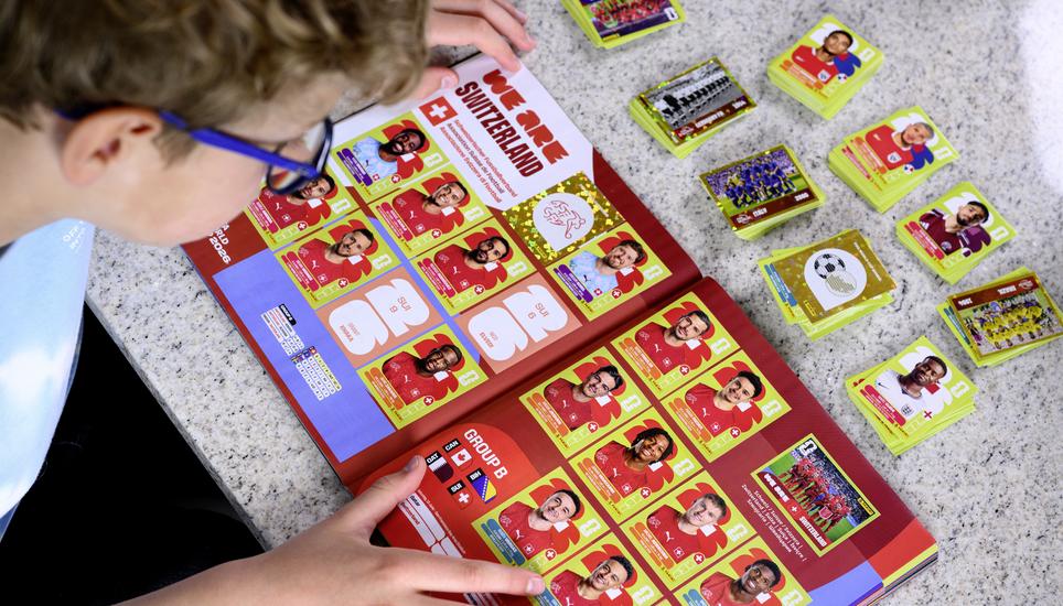 A young collector sticks a Panini World Cup sticker of the Switzerland's soccer national team in the official panini album of the 2026 FIFA World Cup USA Canada Mexico, in Lausanne, Switzerland, Saturday, May 16, 2026. (KEYSTONE/Laurent Gillieron)