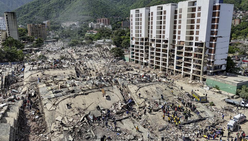 Rescue workers stand on collapsed buildings amid damaged ones along the coast in Caraballeda, La Guaira state, Venezuela, Sunday, June 28, 2026, after earthquakes. (Miguel Medina, Pool photo via AP)