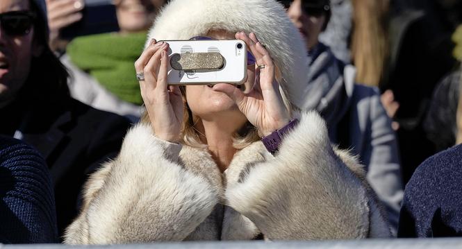 Eine Frau verfolgt ein Pferderennen, fotografiert im Rahmen des White Turf, am Sonntag, 20. Februar 2022 in St. Moritz. (KEYSTONE/Christian Beutler)