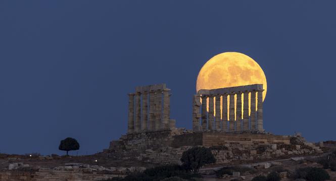 The moon rises behind the ancient marble temple of Poseidon at Cape Sounion, about 70 Km (45 miles) south of Athens, Greece, Saturday, July 20, 2024. (AP Photo/Yorgos Karahalis)