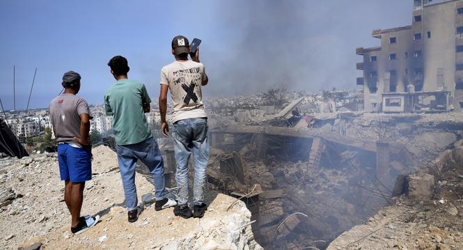 People check a damaged building at the site of an Israeli airstrike in Choueifat, south east of Beirut, Saturday, Sept. 28, 2024. (AP Photo/Hussein Malla)