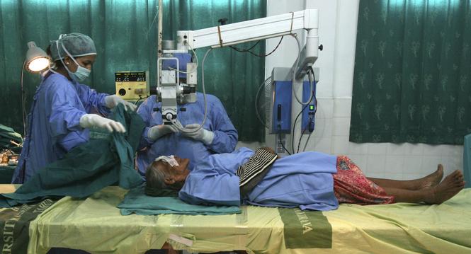 HOLD FOR STORY INDONESIA HEALING THE BLIND BY BINSAR BAKKARA - In this Sunday, Nov. 4, 2012 photo, a patient lies on a makeshift hospital bed for a cataract surgery performed by Dr. Sanduk Ruit, at a military hospital in Padang Sidempuan, North Sumatra, I
