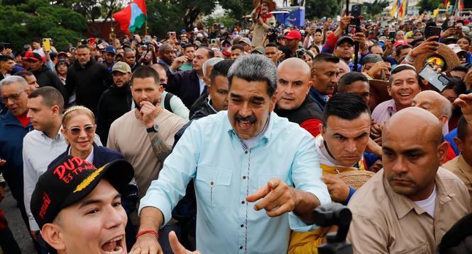 President Nicolas Maduro joins a rally marking the anniversary of the Battle of Santa Ines, which took place during Venezuela's 19th-century Federal War, in Caracas, Venezuela, Wednesday, Dec. 10, 2025. (AP Photo/Cristian Hernandez)