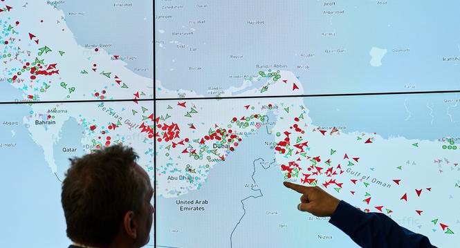 Hapag-Lloyd employees monitor the status of cargo ships in the Strait of Hormuz on a screen, in Hamburg, Germany, Wednesday, April 15, 2026. (AP Photo/Ebrahim Noroozi)