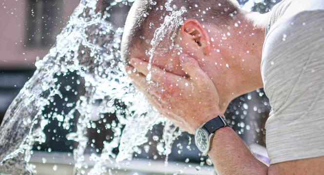 Die Hitze des Sommer ist zurueck, genug trinken und abkuehlen wird empfohlen, Bild zeigt Simon Mueller kuehlt sich am Tell Brunnen in der Stadt ab, am Freitag, 18. August 2023. (Melanie Duchene / Schaffhauser Nachrichten)