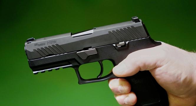 A Sig Sauer P320 handgun is held by a Maine gun shop owner, Tuesday, June 17, 2025. (AP Photo/Robert F. Bukaty)