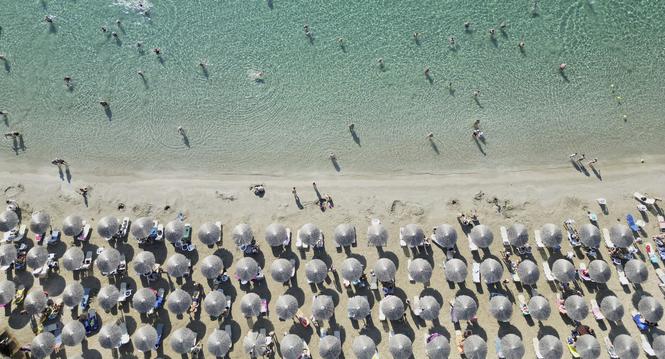 People enjoy the sea in Avlaki beach about 42 kilometers (26 miles) east of Athens, Greece, Wednesday, Aug. 19, 2025. (AP Photo/Thanassis Stavrakis)
