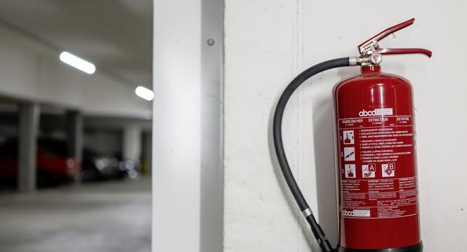 Ein Feuerloescher haengt in der Tiefgarage einer Wohsiedlung, fotografiert am Dienstag, 10. September 2024 in Zuerich. (KEYSTONE/Christian Beutler)
