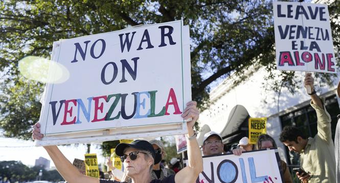 Patty Harland holds up a sign during a rally protesting the United States' involvement in Venezuela, Sunday, Jan. 4, 2026, in Houston. (Elizabeth Conley/Houston Chronicle via AP)
