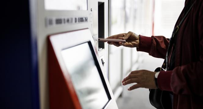 Eine Frau bezahlt an einem SBB Billettautomaten mit ihrem Smartphone, fotografiert am Montag, 1. Juli 2024 am Bahnhof Oerlikon in Zuerich. (KEYSTONE/Christian Beutler)