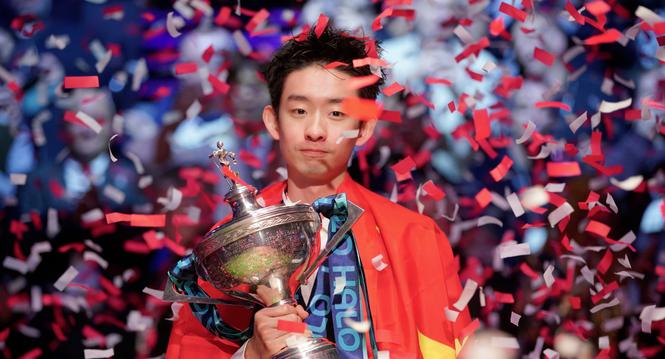 China's Wu Yize poses for the media with the trophy and wearing the Chinese national flag, after winning the World Snooker Championship defeating England's Shaun Murphy in Sheffield, England, Monday, May 4, 2026.(AP Photo/Ian Hodgson)