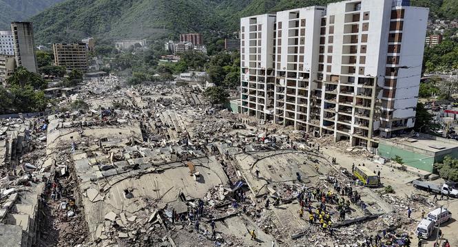 Rescue workers stand on collapsed buildings amid damaged ones along the coast in Caraballeda, La Guaira state, Venezuela, Sunday, June 28, 2026, after earthquakes. (Miguel Medina, Pool photo via AP)